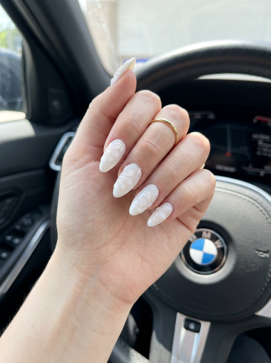 Embossed Floral Milky Almond Nails 2026 - Romantic Bridal Shower Milky white embossed floral almond nails for almond summer nails 2026 for fair skin. Romantic bridal shower style.
