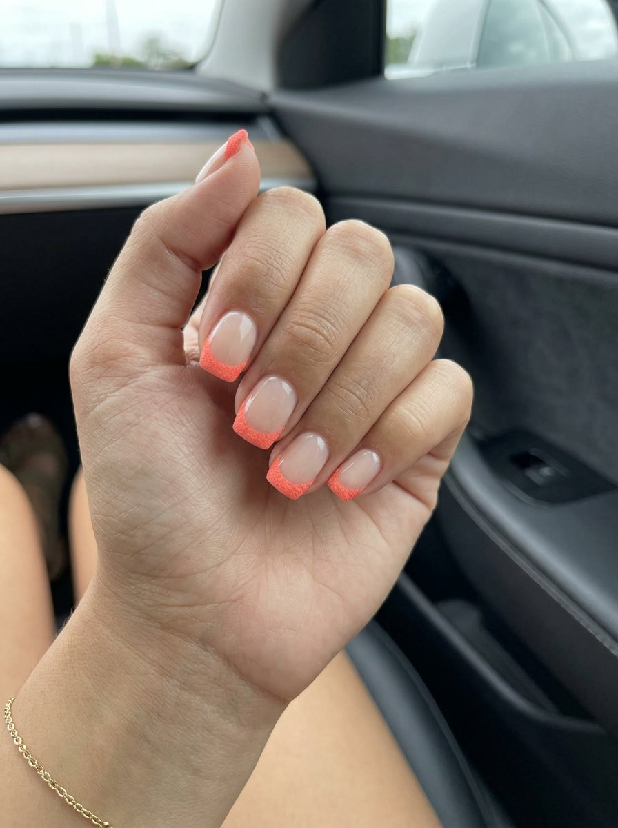 Cute summer nails 2026: Textured coral reverse French tip on short squoval nails for a playful, modern brunch look.