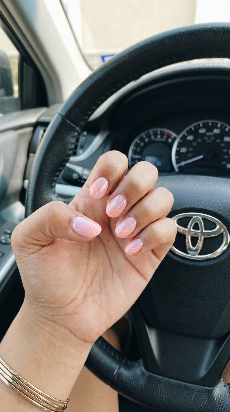 Fun summer nails 2026: Medium squoval nails with sheer nude base and soft peach pearlescent swirls.