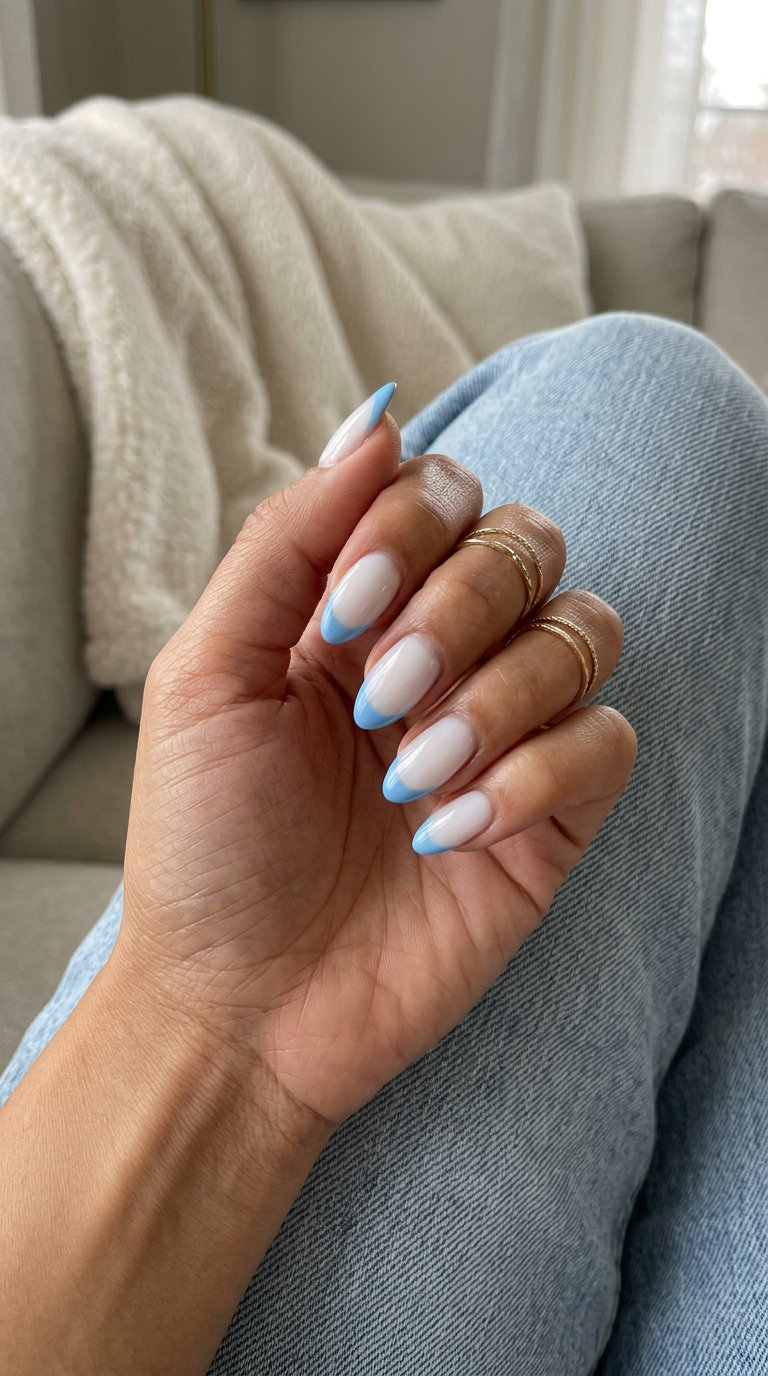 Sky Blue Moon French summer dip nails 2026: sheer milky white base with a sky blue reverse French tip on almond nails.