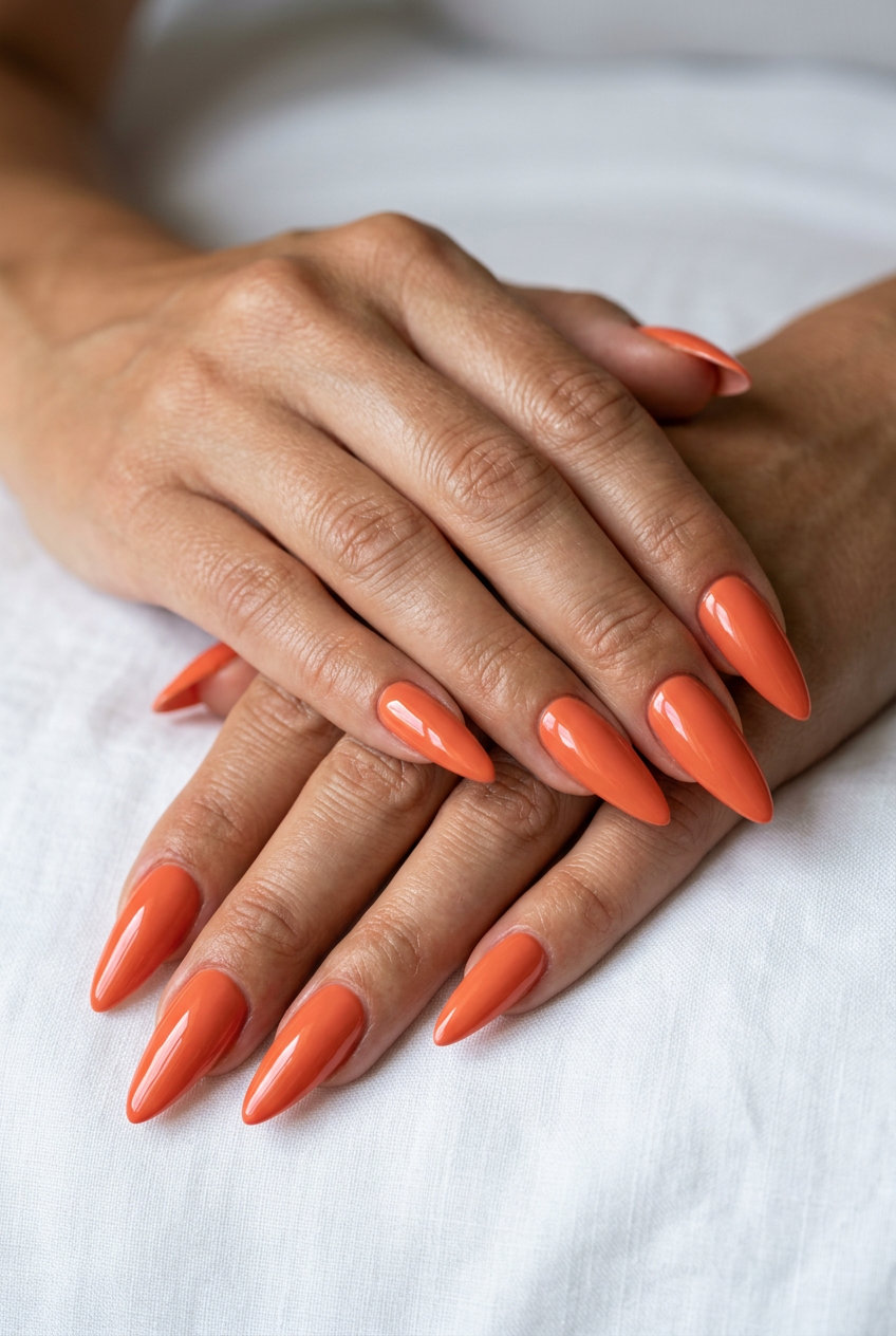 Trendy Summer Nails 2026: Coral Stiletto Trendy summer nails 2026: Sultry coral solid glossy stiletto nails for date nights and summer parties.