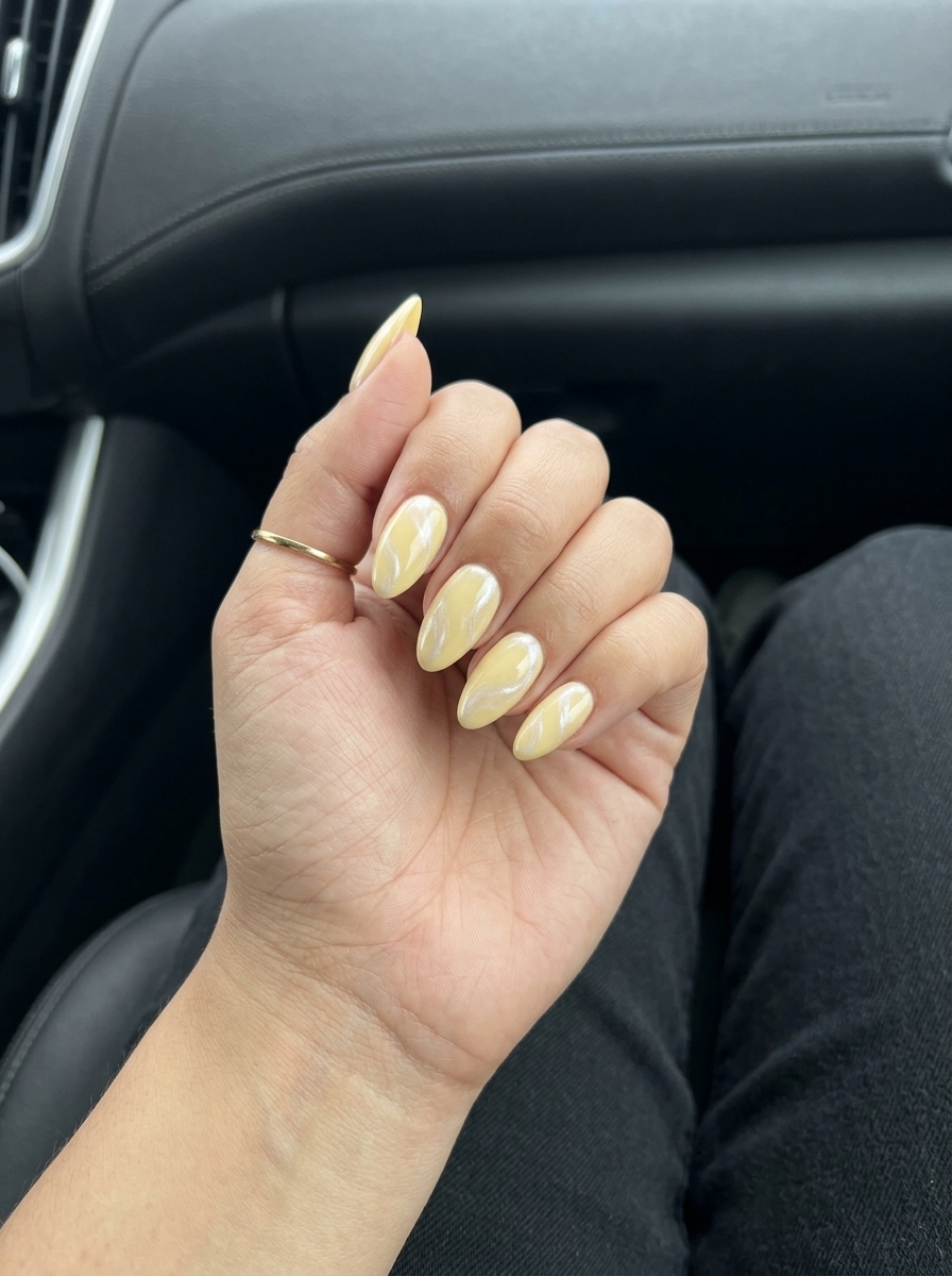 Butter yellow pearlescent swirls: elegant gel nails for weddings and brunch.