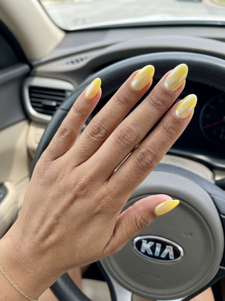 Vibrant canary yellow chrome stilettos with holographic shimmer for parties. Yellow summer nails 2026.