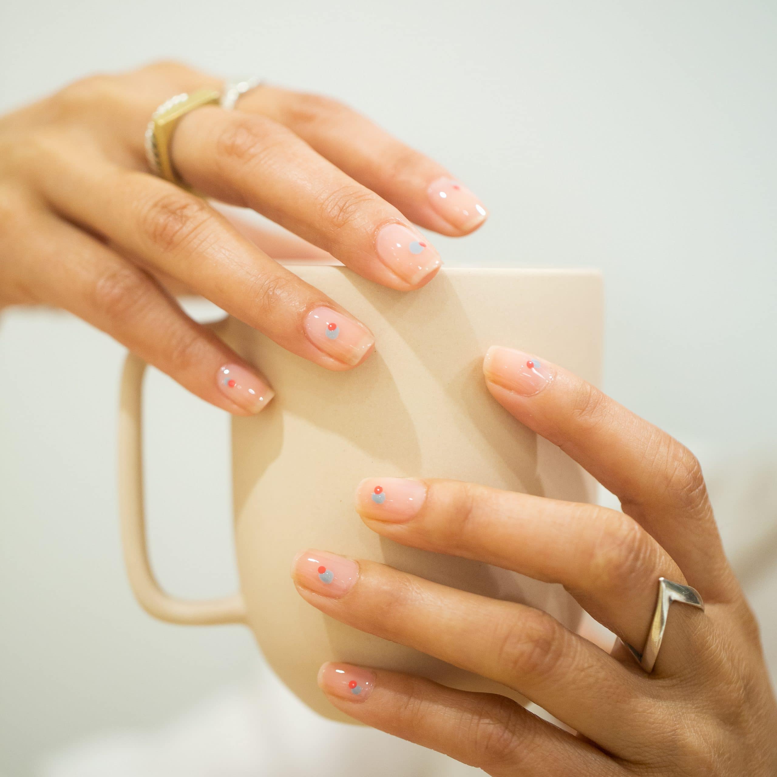 Short Round Nude with Scattered Blue and Red Dots — Minimalist Nails