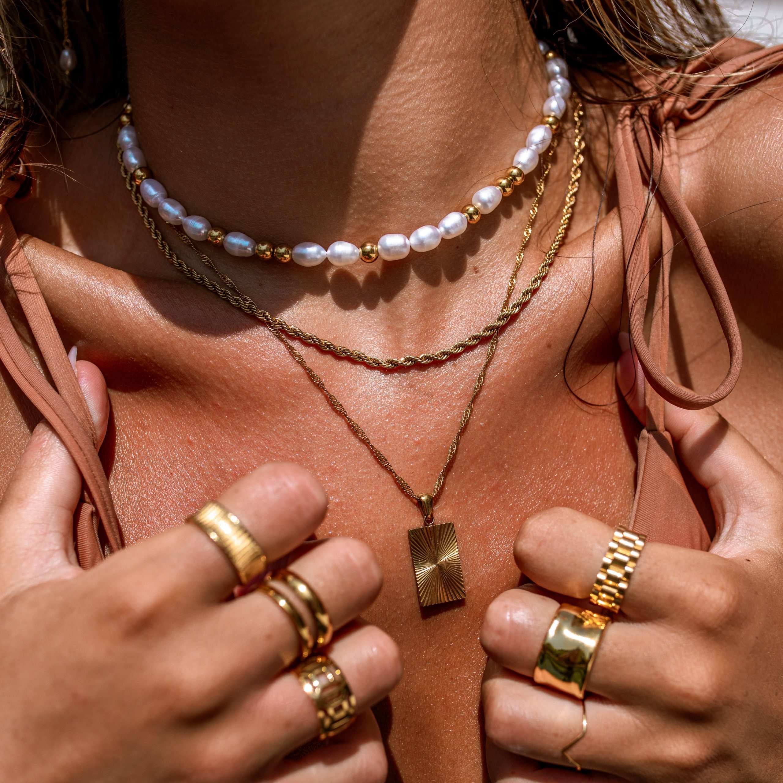 Layered Gold Necklaces with Rectangular Pendant on Bikini Layered Gold Necklaces with Rectangular Pendant on Bikini — Gold Jewelry