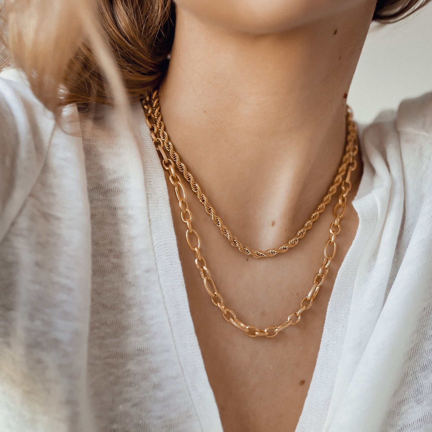 Layered Gold Chains on White V-Neck Top Layered Gold Chains on White V-Neck Top — Chunky Jewelry