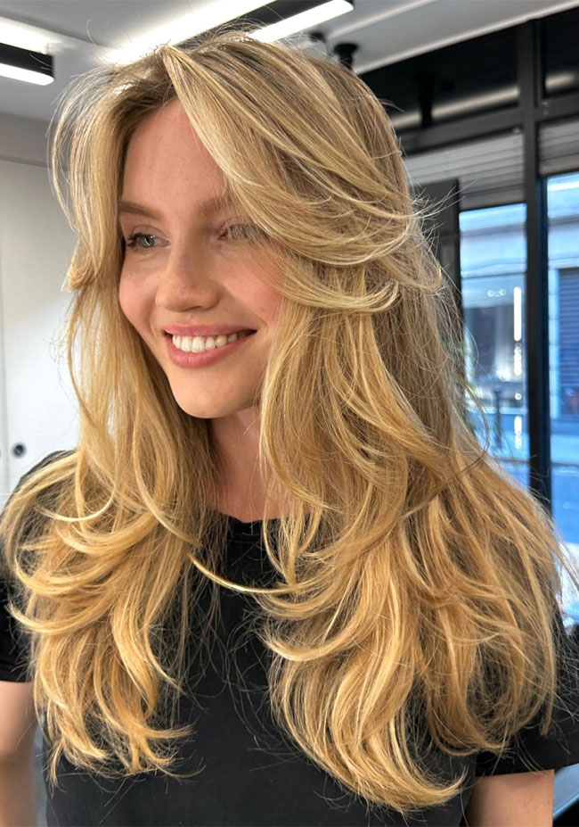Effortless Blonde Long Layers and Curtain Bangs with Voluminous Blowout