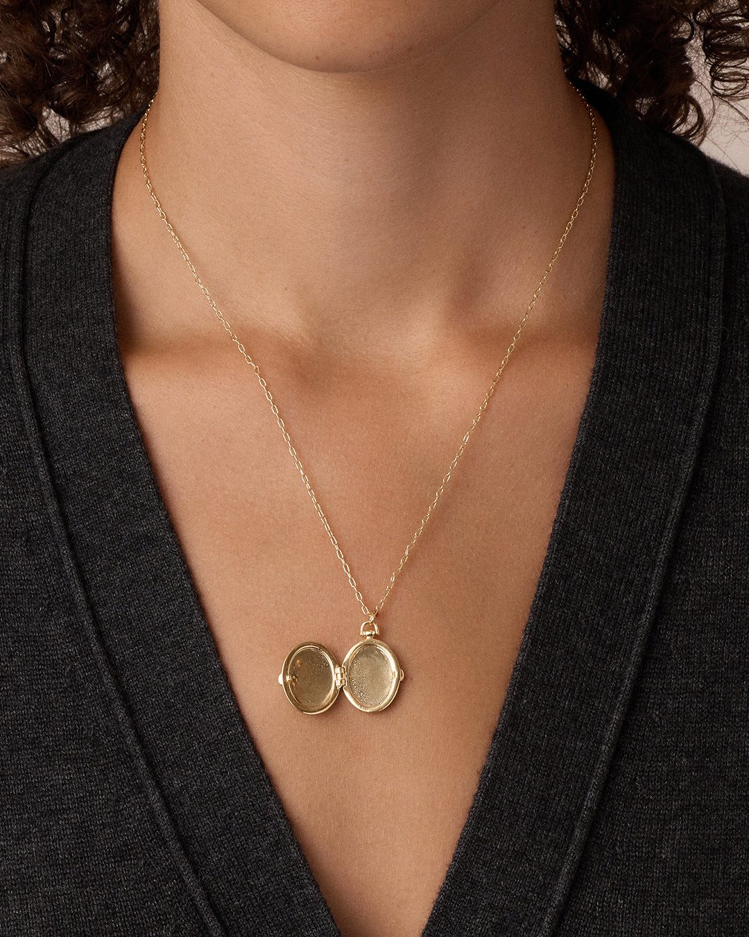 Open Gold Locket on Dark Grey V-Neck Sweater — Locket Necklaces