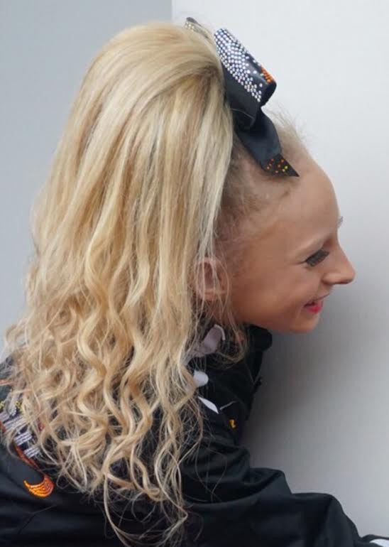 High Ponytail With Loose Curls and Patterned Bow — Cheer Hairstyles