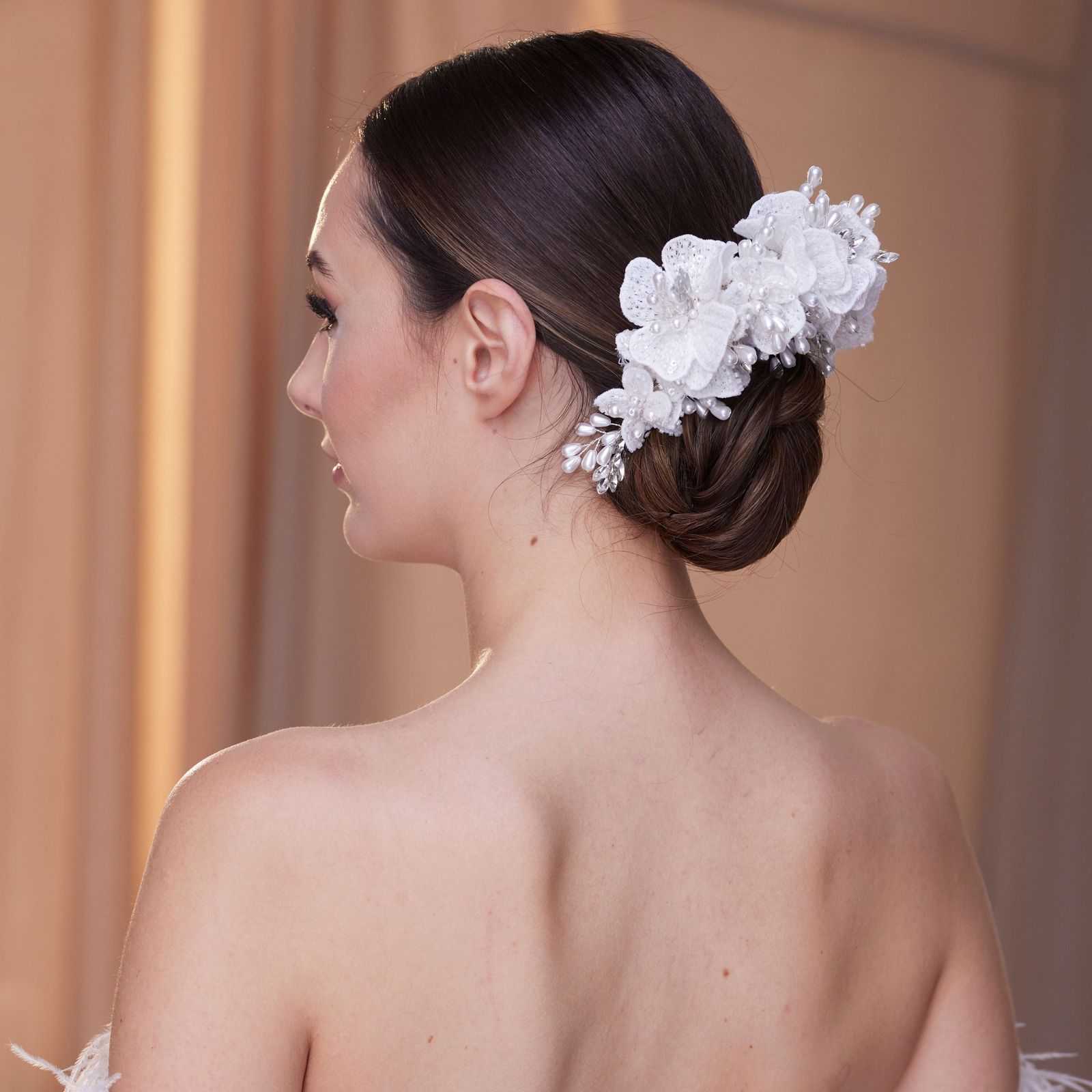 Elegant Dark Brown Bun with Floral Accessory — Wedding Low Bun