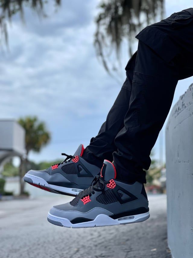 Bold Accents: Grey and Red Jordan 4s with Black Cargo Pants Bold Accents: Grey and Red Jordan 4s with Black Cargo Pants — Jordan 4 Outfits