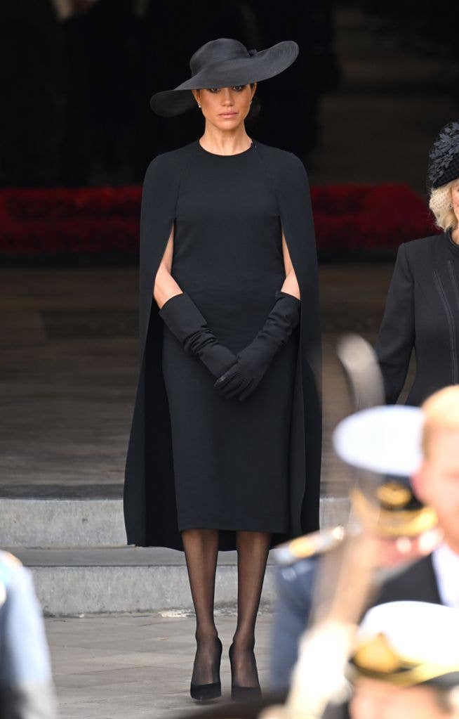 Elegant Black Cape Dress with Wide-Brimmed Hat for Somber Occasions Elegant Black Cape Dress with Wide-Brimmed Hat for Somber Occasions — Funeral Outfits