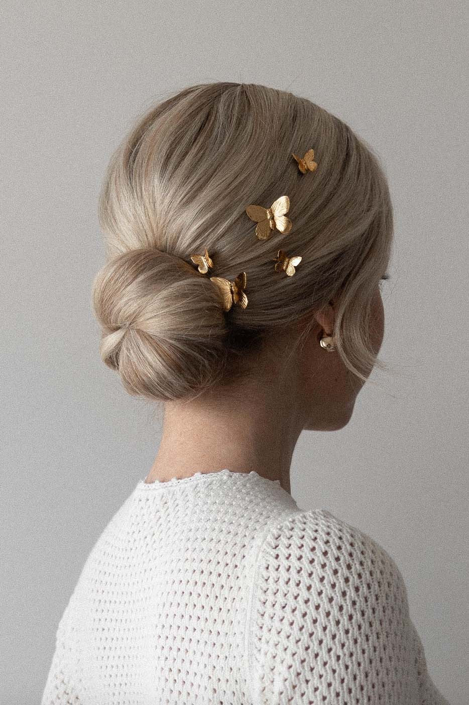 Wavy Ash Blonde Low Bun with Loose Strands — Low Bun with Bangs