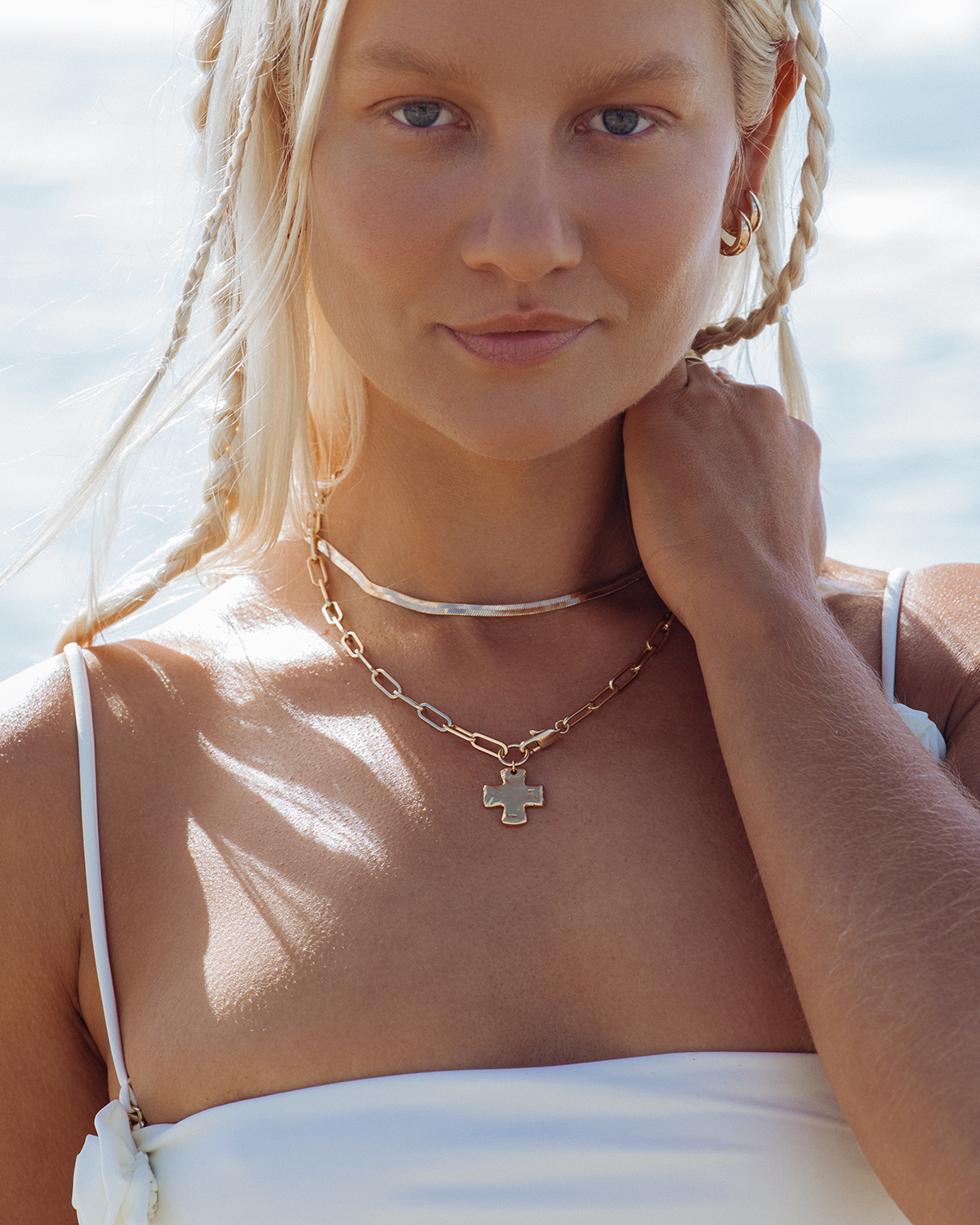 Layered Necklaces with Cross Pendant on White Top Layered Necklaces with Cross Pendant on White Top — Chunky Jewelry