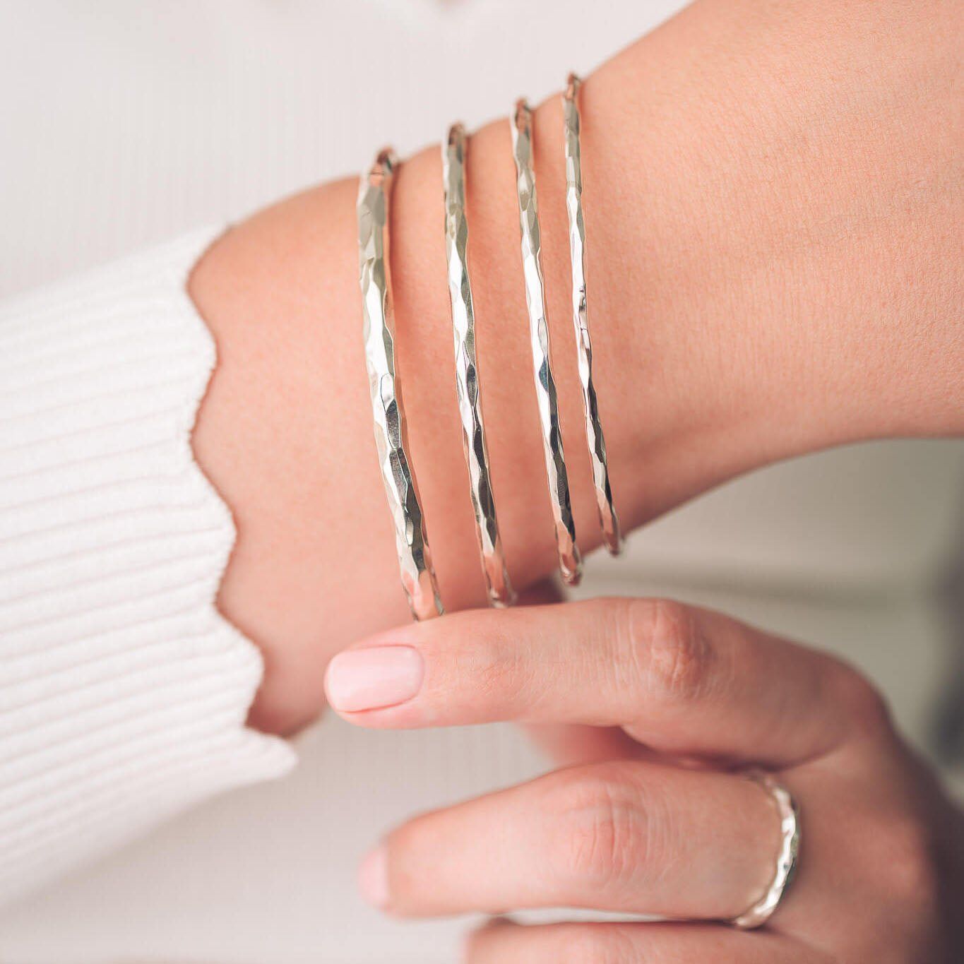 Hammered Silver Bangles with a White Knit Sweater — Bangle Stacks