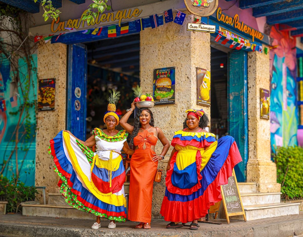 Cultural Contrast: Traditional Dresses and Modern Orange Cutout — Cartagena Outfits