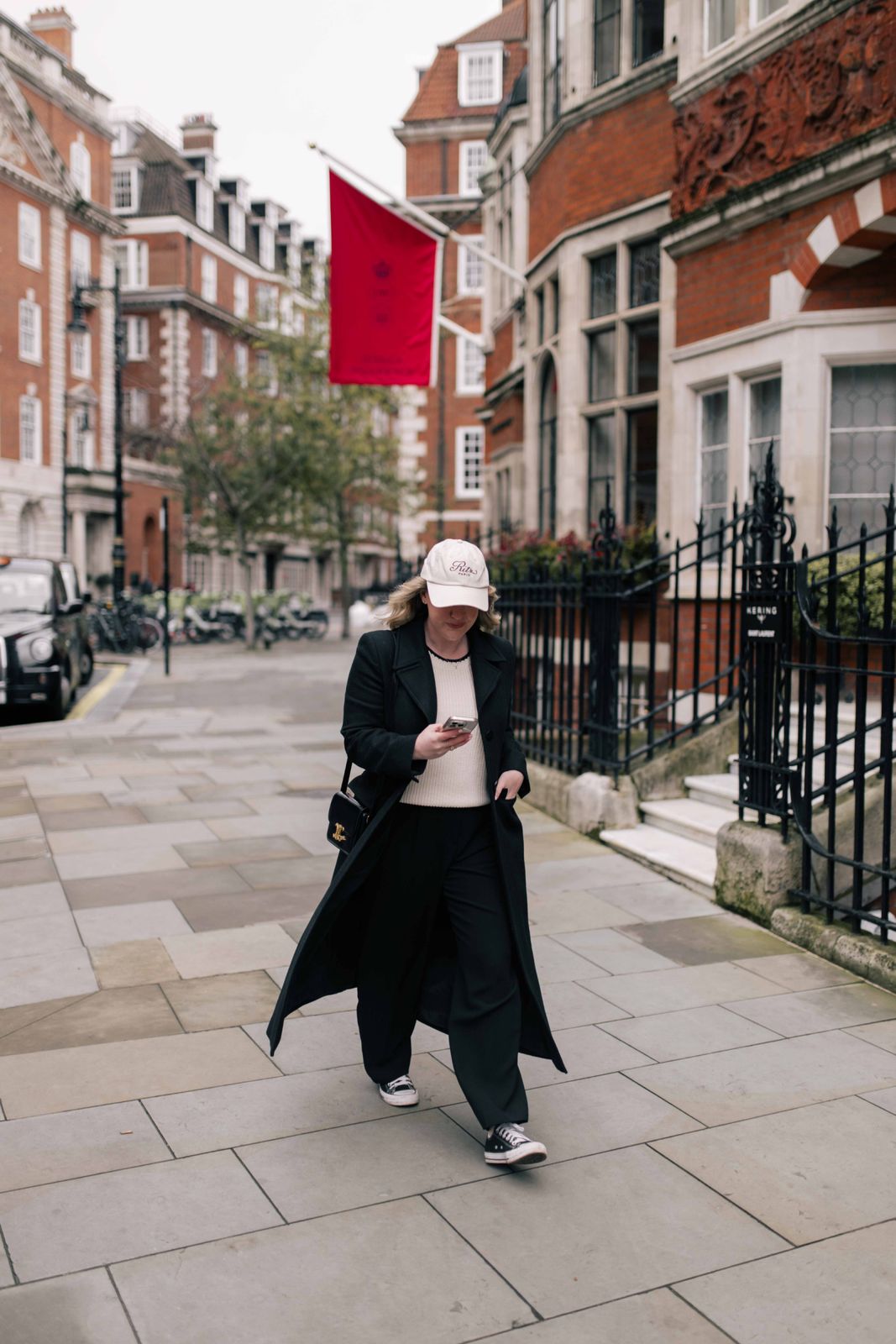 Black Trench Coat Over Cream Sweater and Trousers — Long Flight Outfits