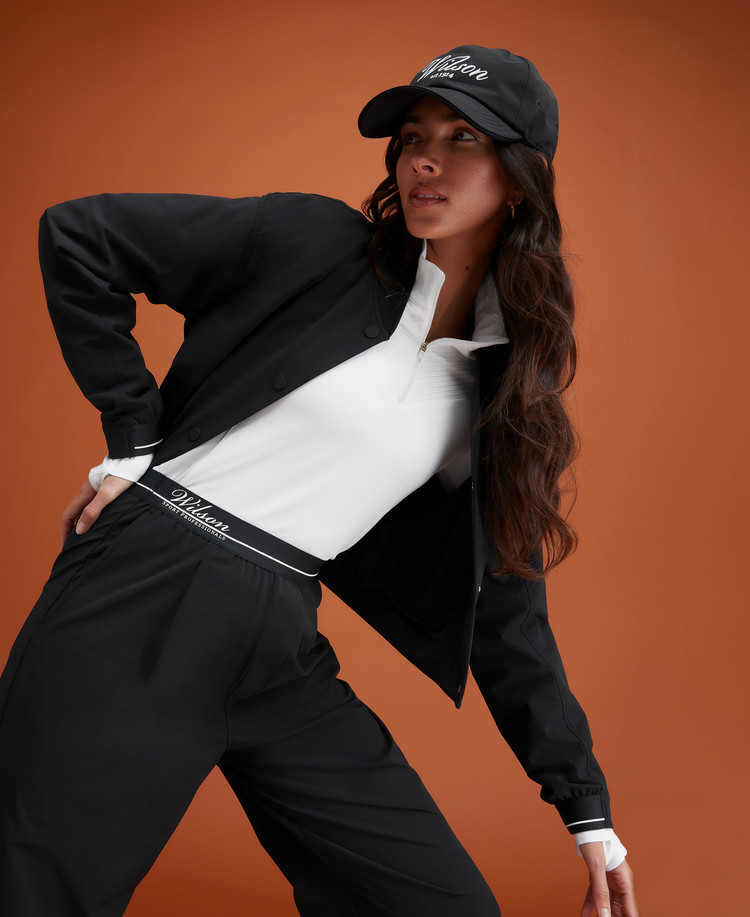 Black Bomber Jacket Over White Top for a Sporty Tennis Ensemble — Tennis Match Outfits