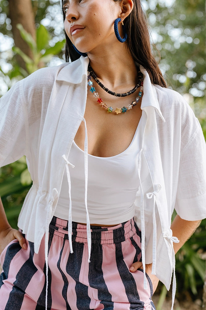 White Shirt with Tie Details Paired with Striped Trousers White Shirt with Tie Details Paired with Striped Trousers — Blouses