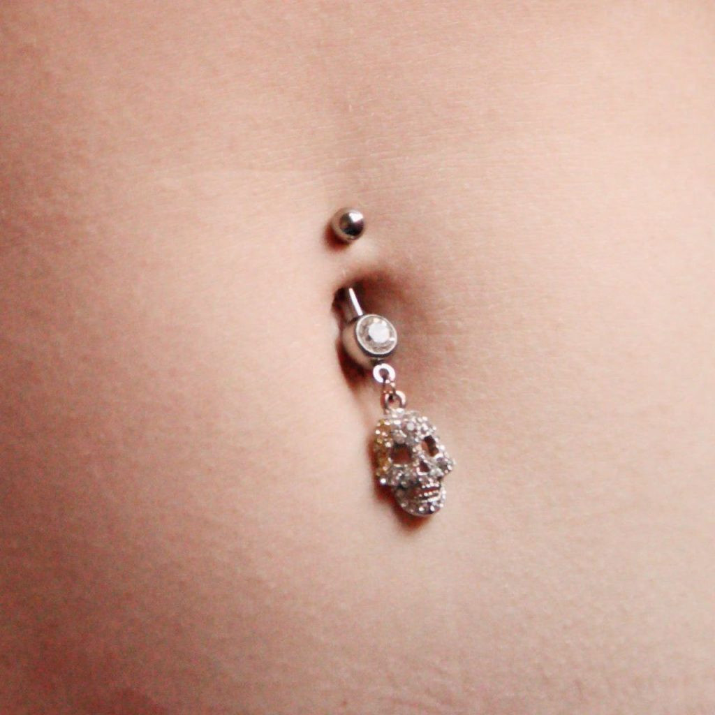 Edgy Appeal: Skull Charm Belly Piercing with Silver Barbell — Belly Button Piercing Ideas