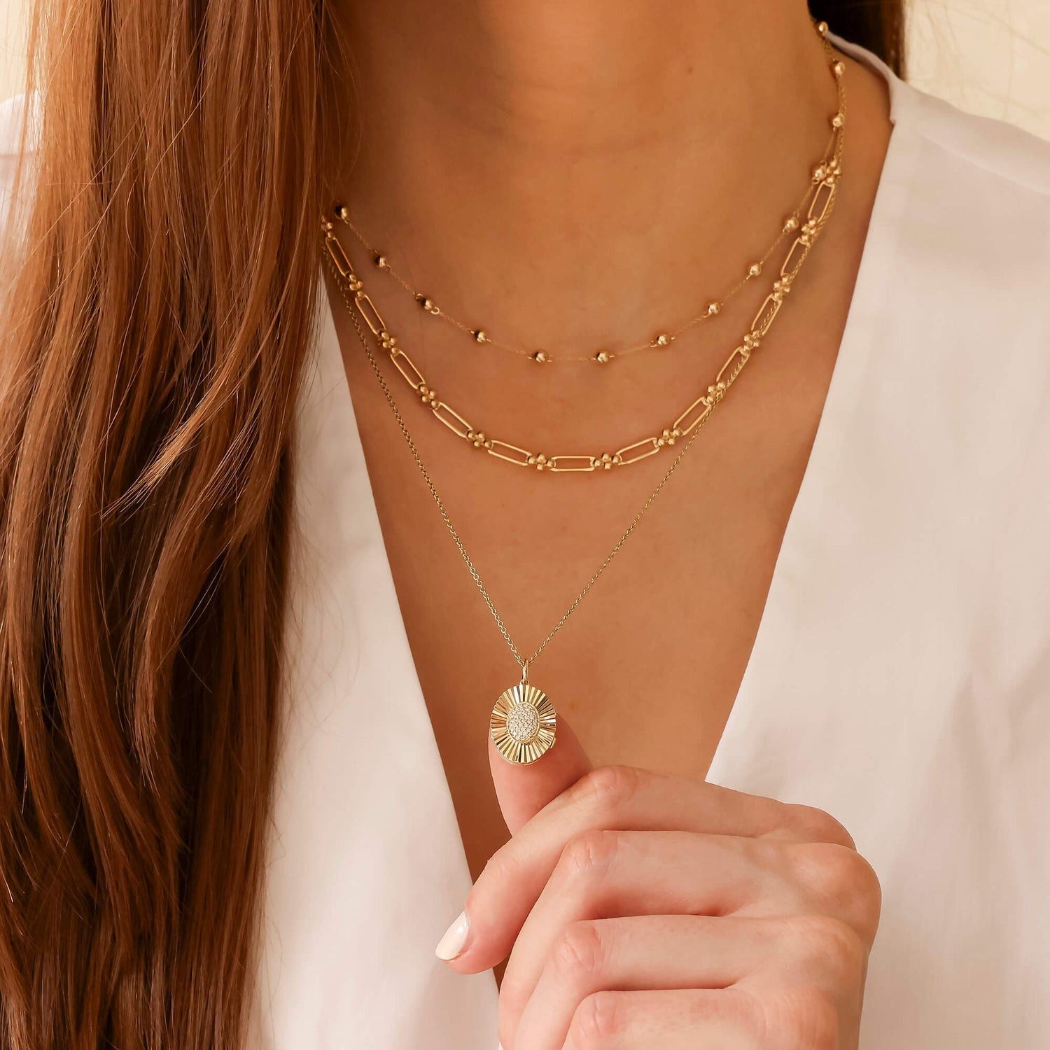 Sunburst Locket Pendant Among Layered Chains — Locket Necklaces