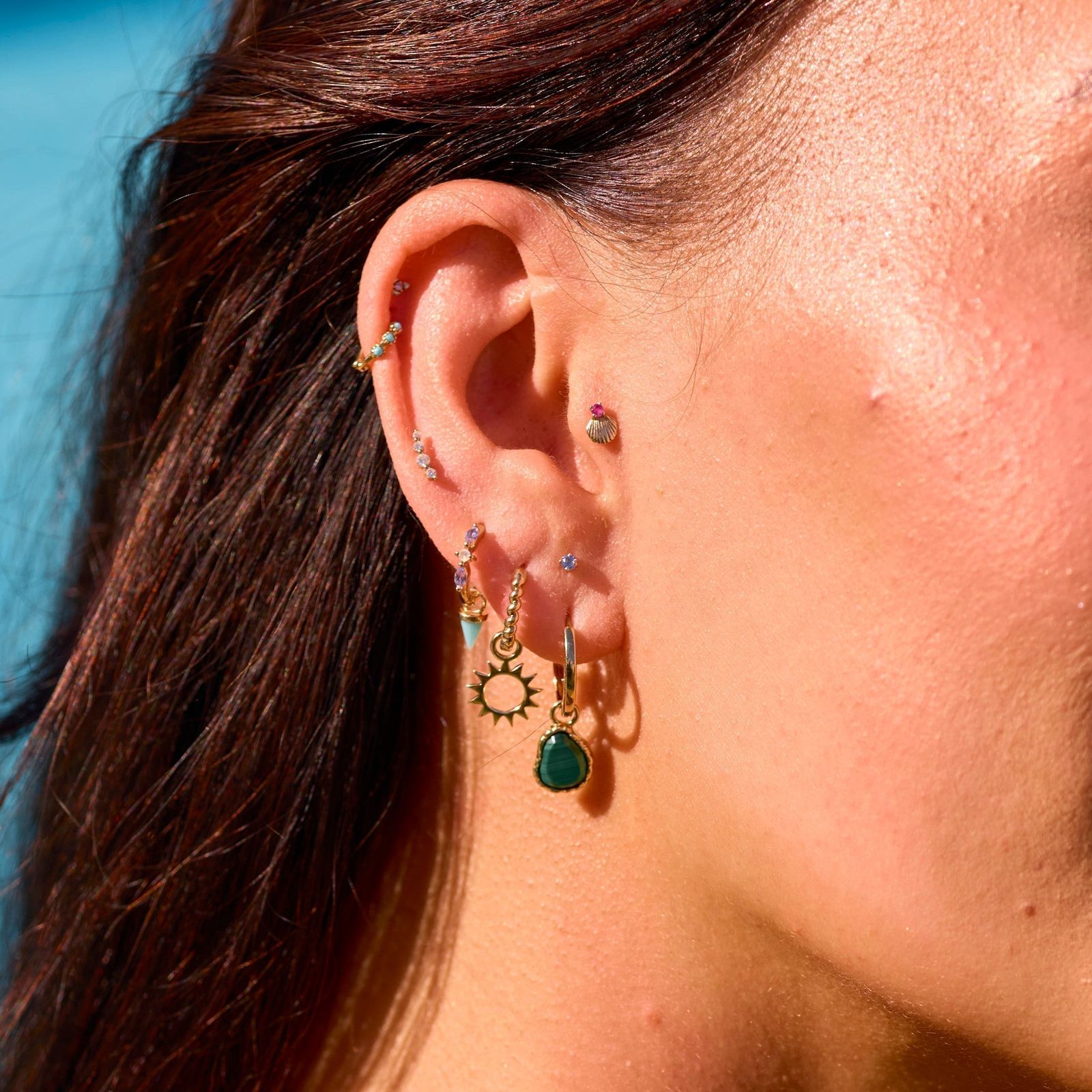 Eclectic Gold Piercings with Turquoise, Shell, and Sun Charms Eclectic Gold Piercings with Turquoise, Shell, and Sun Charms — Ear Piercing Ideas