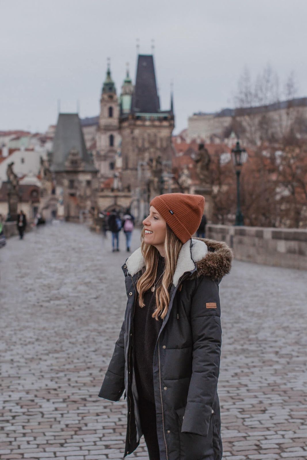 Charcoal Puffer Coat with Rust Beanie and Dark Sweater — Prague Outfits