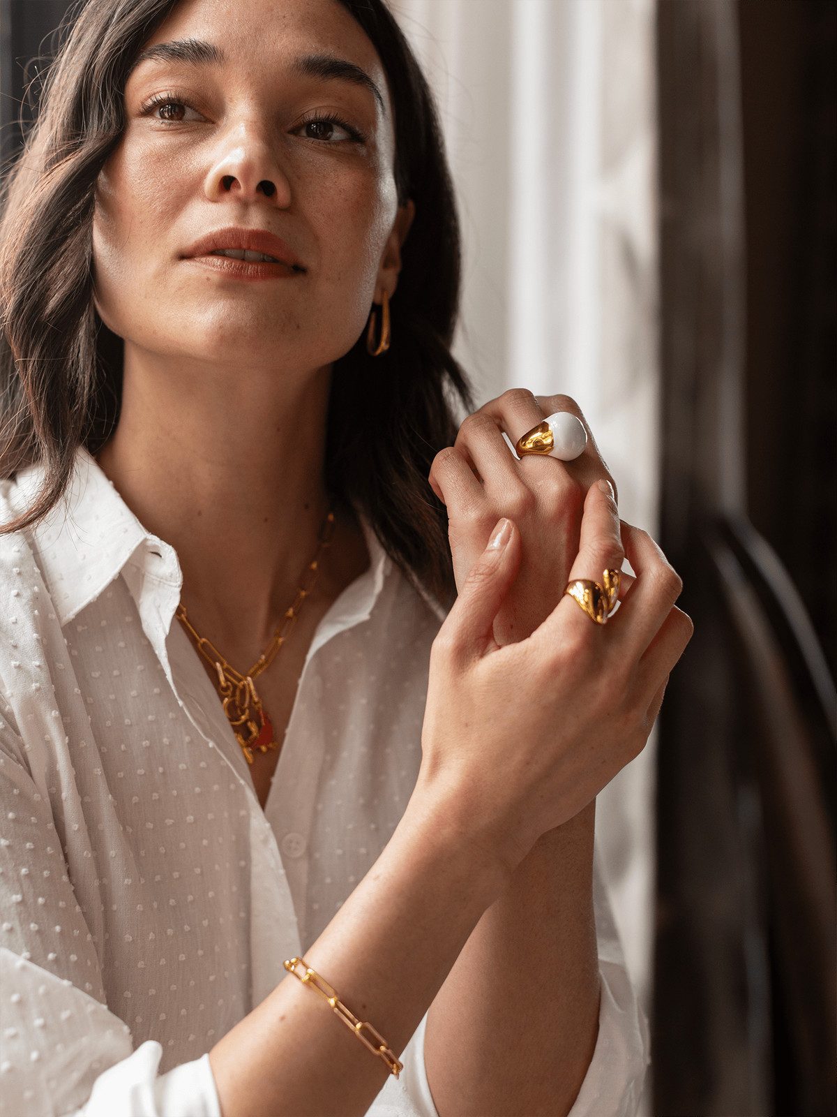 Stacked Gold Rings with White Accents on Textured Shirt — Cocktail Rings