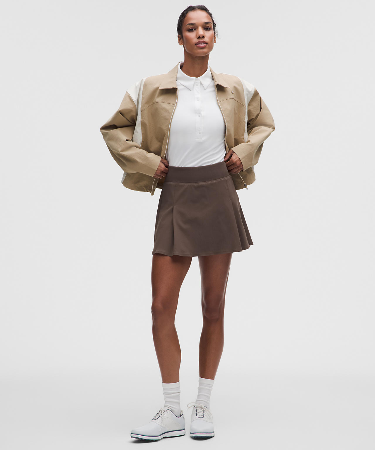 Color-Blocked Jacket Over White Polo and Brown Skirt — Golf Tournament Outfits