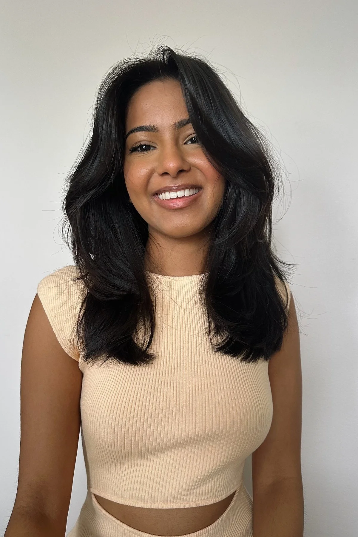 Minimalist Appeal: Black Hair Layers with Subtle Bangs and Peach Top — Bangs with Layers