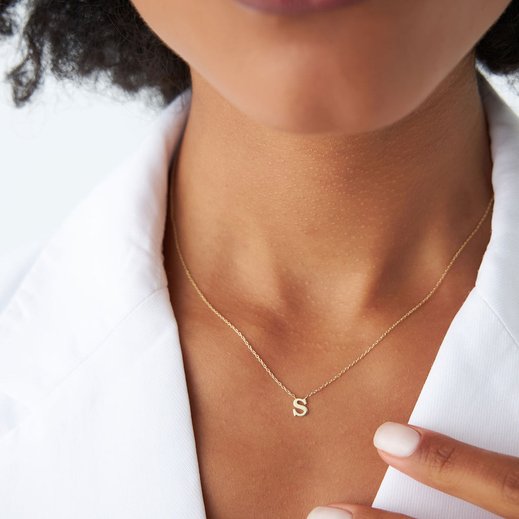 Delicate Gold Initial 'S' Necklace on White Jacket Delicate Gold Initial 'S' Necklace on White Jacket — Initial Necklaces