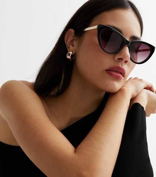 Sophisticated Contrast: Black Cat-Eye Sunglasses with One-Shoulder Top — Sunglasses for Oval Face