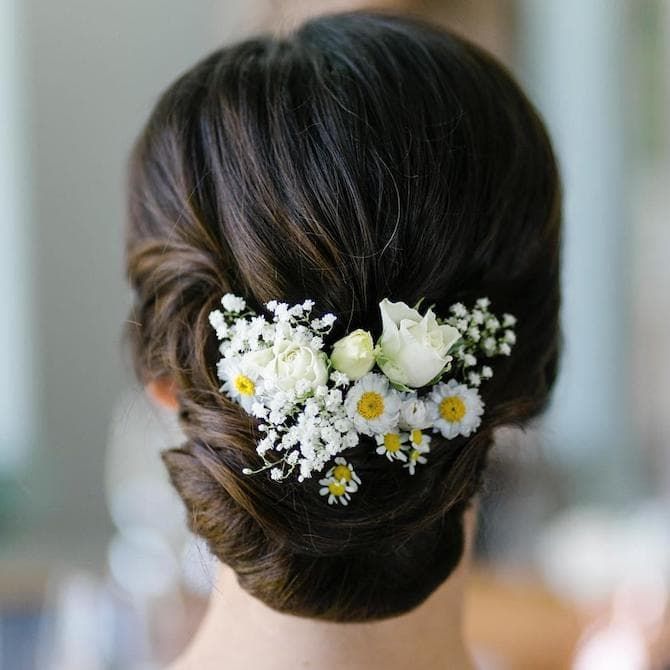 Sleek Low Bun with Floral Accessory — Wedding Hairstyles with Flowers