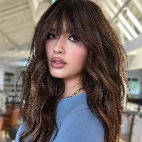 Casual Comfort: Dark Brown Wavy Hair with Full Bangs and a Blue T-Shirt — Long Bangs