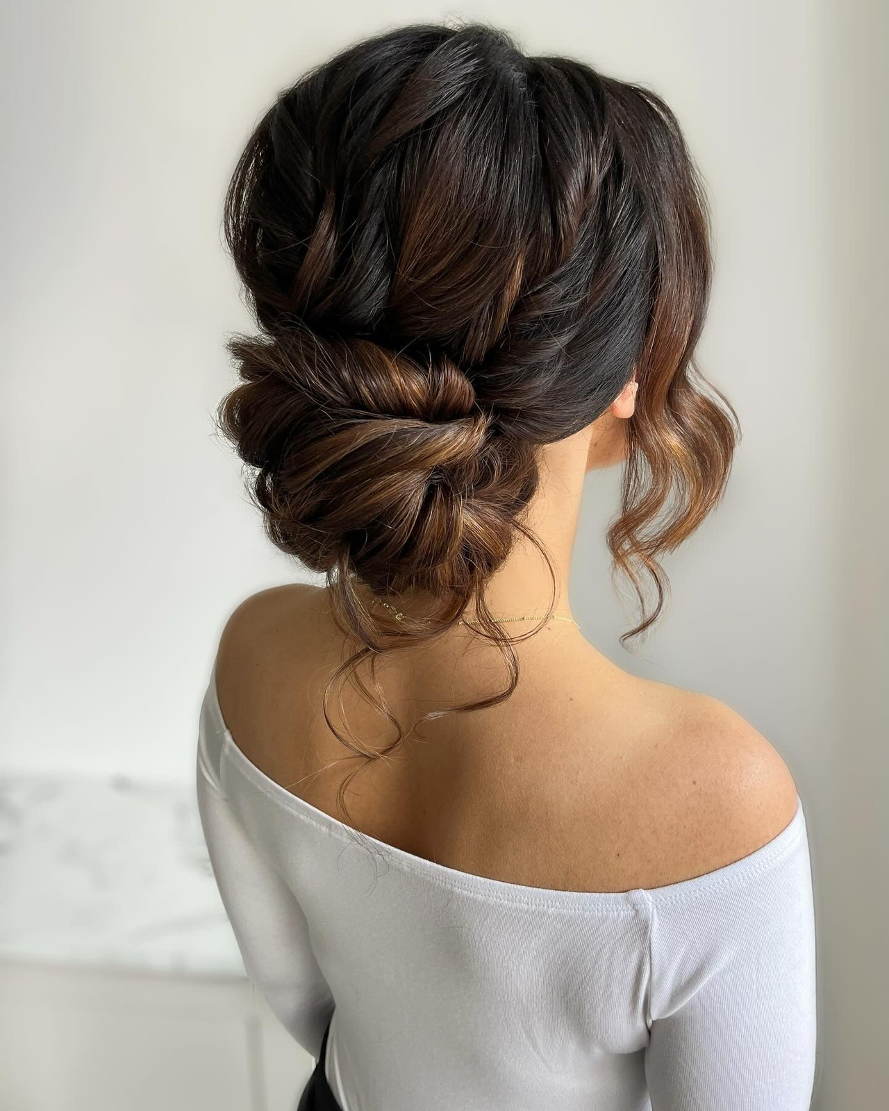 Messy Dark Brown Bun with Twists Messy Dark Brown Bun with Twists — Low Bun with Curtain Bangs