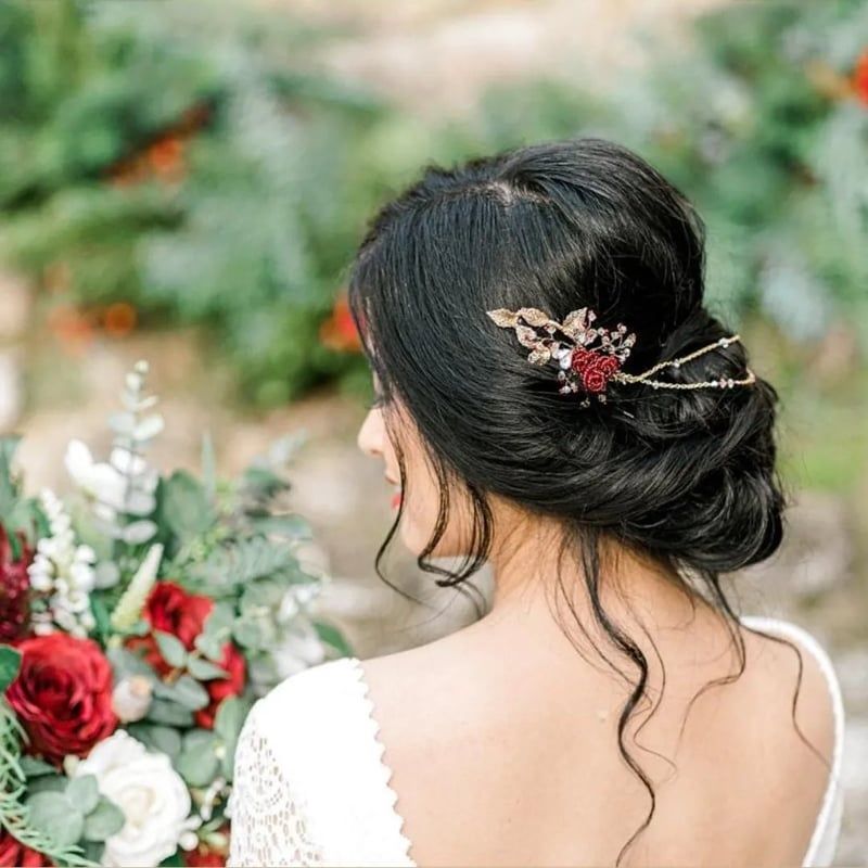 Elegant Updo with Ornate Red Flower Accessory — Wedding Hairstyles with Flowers