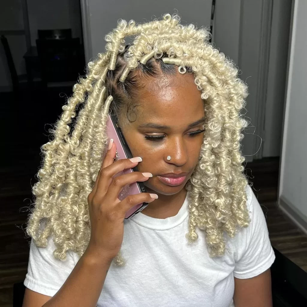 Mid-Back Blonde Butterfly Locs — The Locs Are Voluminous And Curly