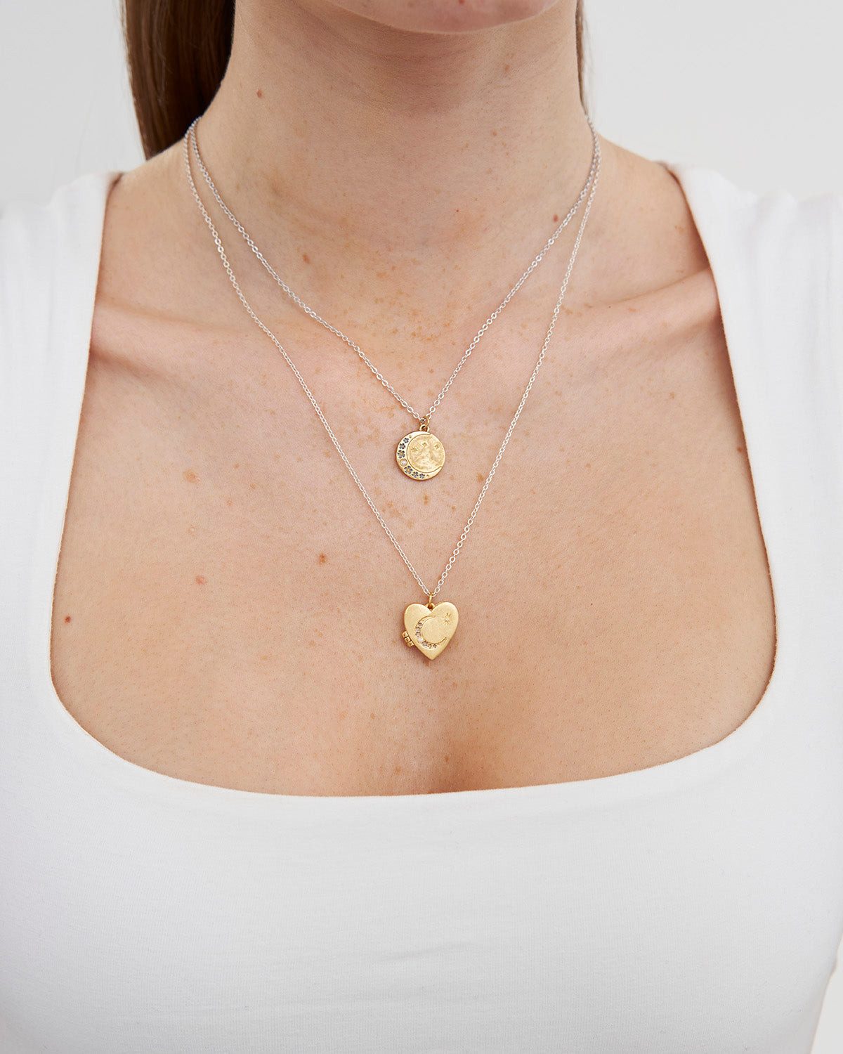 Silver Coin and Gold Locket Layered on White Tee — Locket Necklaces