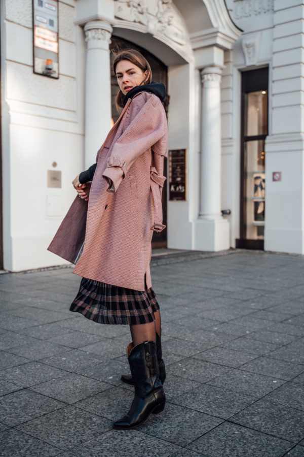 Winter Warmth: Black Cowboy Boots with Plaid Skirt and Patterned Coat — Cowboy Boots with Skirt Outfits